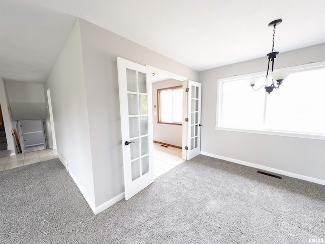 spare room featuring light carpet and french doors