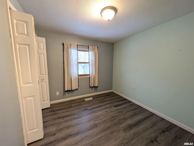 spare room with dark hardwood / wood-style flooring