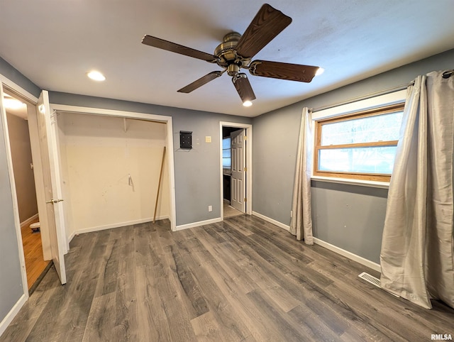 unfurnished bedroom featuring ceiling fan, dark wood-type flooring, and a closet