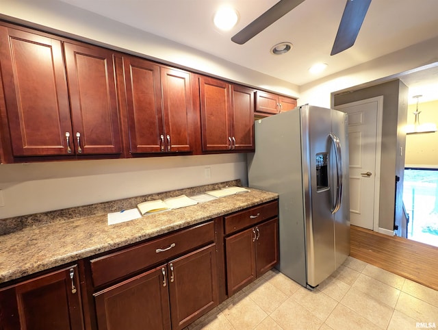 kitchen featuring stainless steel fridge with ice dispenser and light stone counters