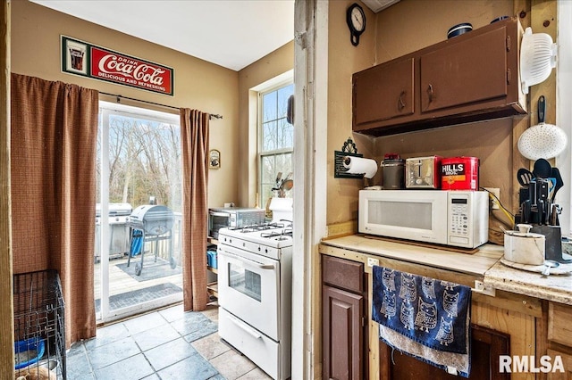 kitchen with light tile patterned flooring and white appliances