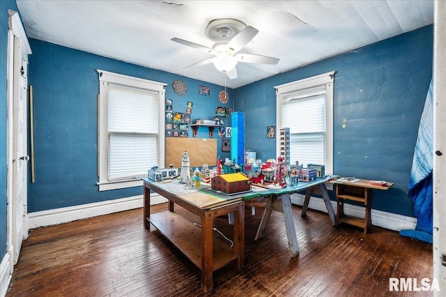 home office with dark hardwood / wood-style floors and ceiling fan