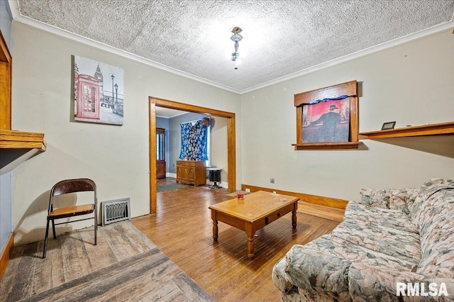 living room with wood-type flooring, a textured ceiling, and ornamental molding