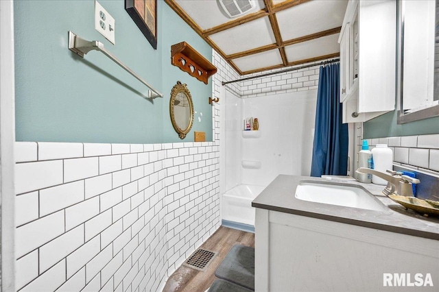 bathroom featuring shower / bath combo with shower curtain, vanity, wood-type flooring, and tile walls