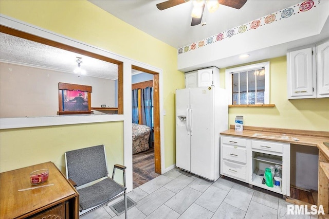 kitchen with white cabinets, light wood-type flooring, and white fridge with ice dispenser