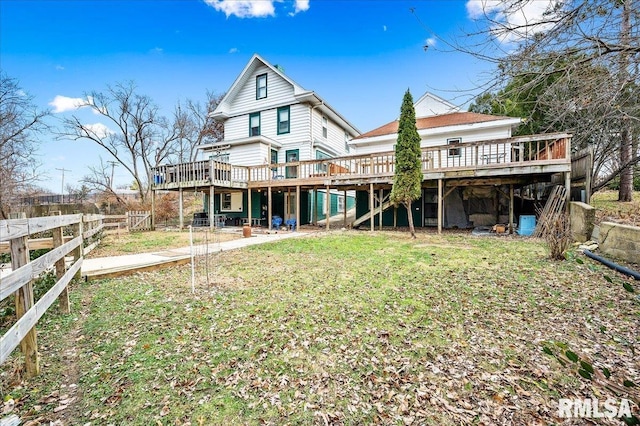 back of property featuring a lawn and a wooden deck