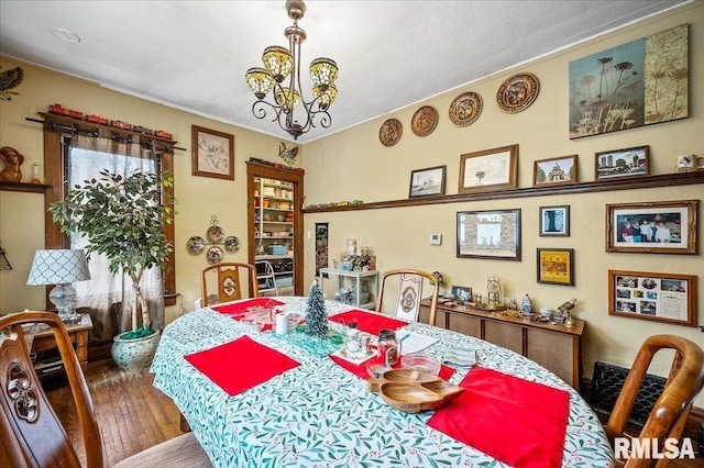 dining room featuring a chandelier, hardwood / wood-style flooring, and ornamental molding