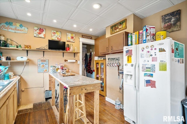 kitchen with tile counters, wood-type flooring, white refrigerator with ice dispenser, and light brown cabinets