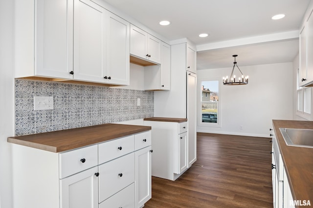 kitchen featuring dark hardwood / wood-style floors, white cabinetry, and wooden counters