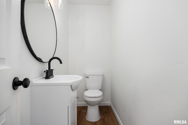 bathroom with hardwood / wood-style floors, vanity, and toilet