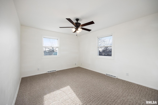 carpeted empty room with a wealth of natural light and ceiling fan