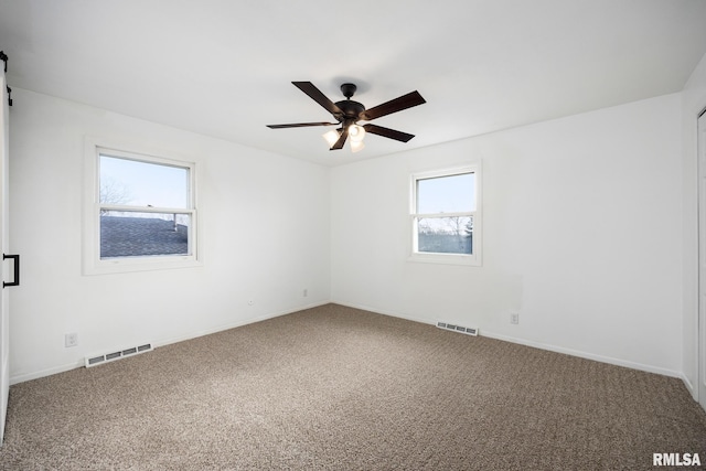 carpeted spare room with ceiling fan