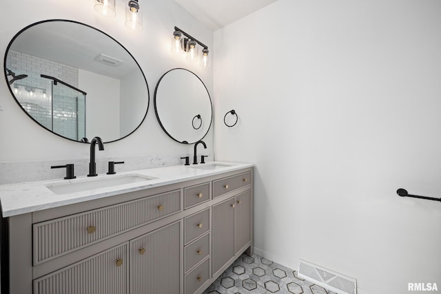 bathroom with tile patterned flooring, vanity, and walk in shower