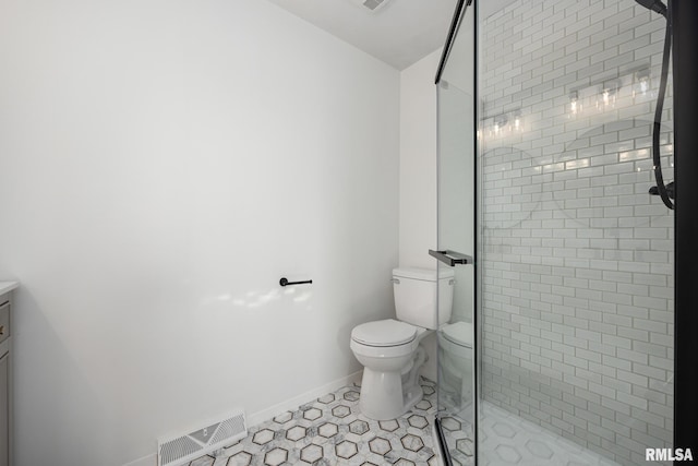 bathroom with tile patterned floors, toilet, vanity, and tiled shower