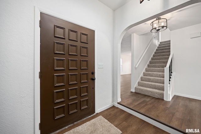 foyer featuring dark wood-type flooring and a notable chandelier