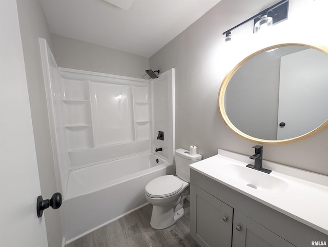 full bath with toilet,  shower combination, wood finished floors, and vanity