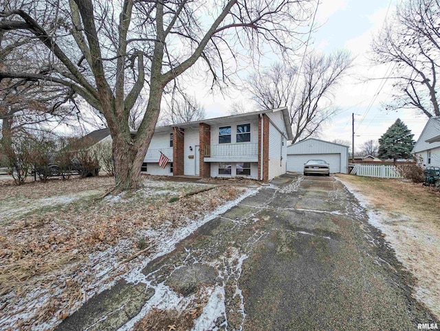 view of front of home with a garage, brick siding, an outdoor structure, and fence