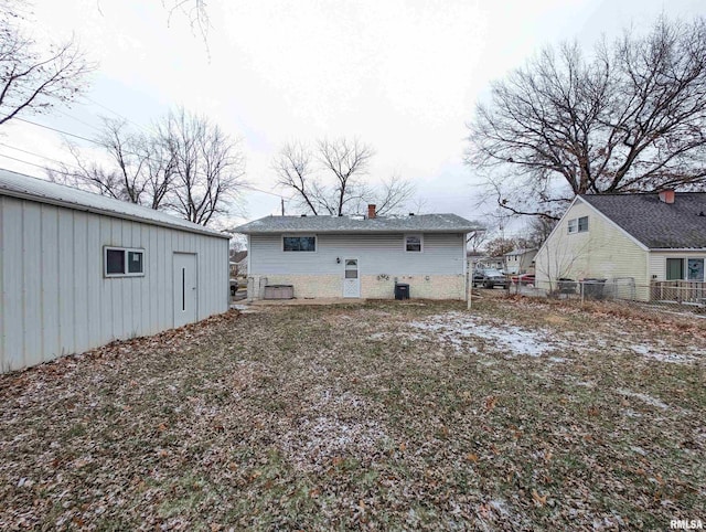 rear view of house featuring a chimney, fence, and cooling unit