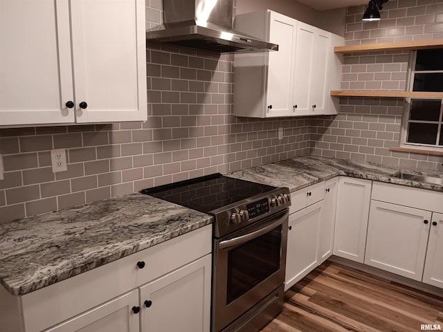 kitchen with open shelves, white cabinets, backsplash, wall chimney exhaust hood, and stainless steel range with electric stovetop