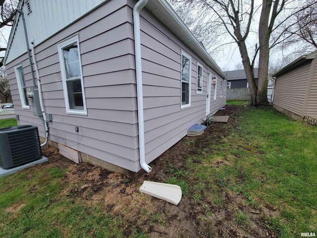 view of home's exterior featuring central air condition unit and a yard