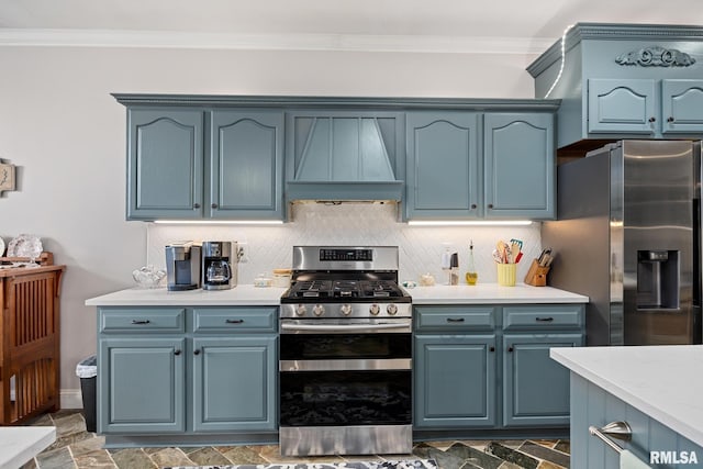 kitchen featuring blue cabinetry, premium range hood, and appliances with stainless steel finishes