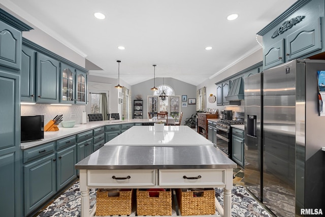 kitchen featuring lofted ceiling, crown molding, appliances with stainless steel finishes, tasteful backsplash, and decorative light fixtures