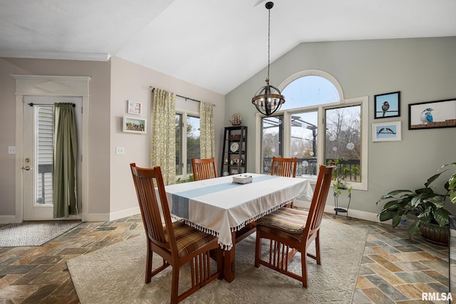 dining room with vaulted ceiling, plenty of natural light, and a notable chandelier