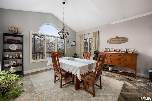 dining area with lofted ceiling and an inviting chandelier