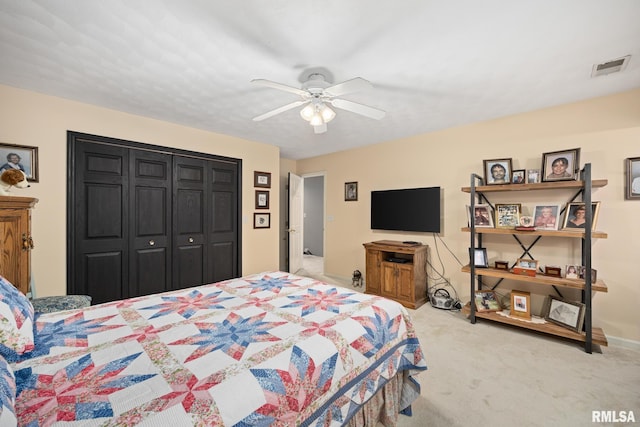 carpeted bedroom with ceiling fan and a closet