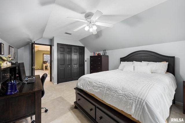 carpeted bedroom with a closet, lofted ceiling, and ceiling fan