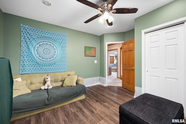 living room featuring wood-type flooring and ceiling fan