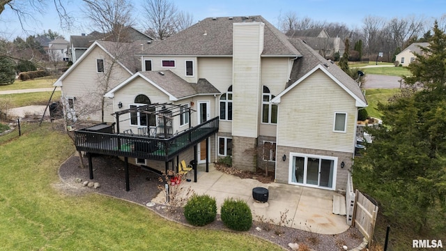 back of property with a yard, a deck, and a patio area