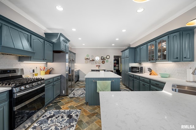 kitchen with custom exhaust hood, backsplash, sink, ornamental molding, and appliances with stainless steel finishes