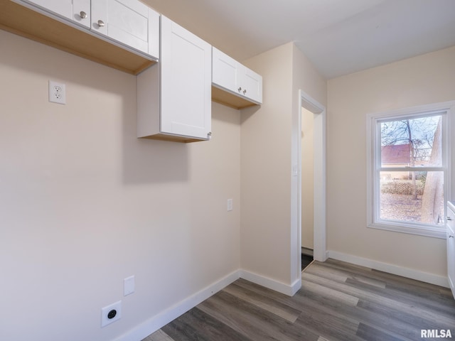 laundry room featuring hookup for an electric dryer, dark hardwood / wood-style floors, and cabinets