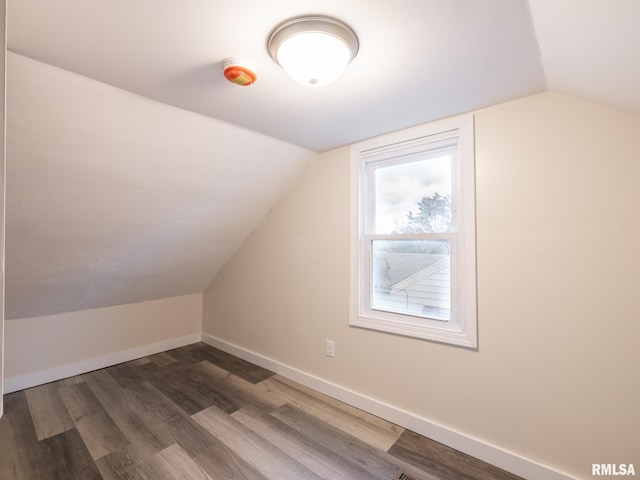 additional living space with dark hardwood / wood-style flooring and vaulted ceiling