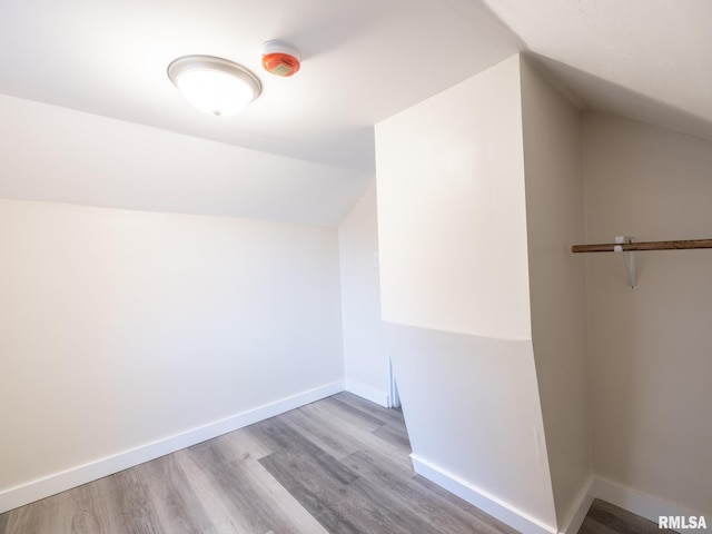 bonus room with light wood-type flooring and vaulted ceiling