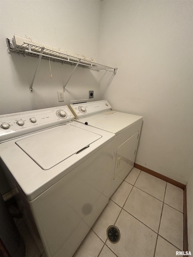 laundry area with light tile patterned floors and washing machine and clothes dryer