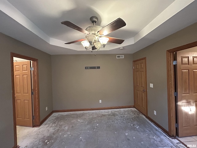 spare room featuring a tray ceiling and ceiling fan