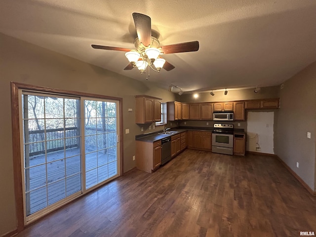 kitchen featuring rail lighting, sink, ceiling fan, appliances with stainless steel finishes, and dark hardwood / wood-style flooring