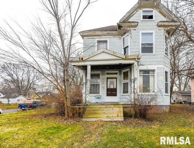 victorian-style house with a front lawn