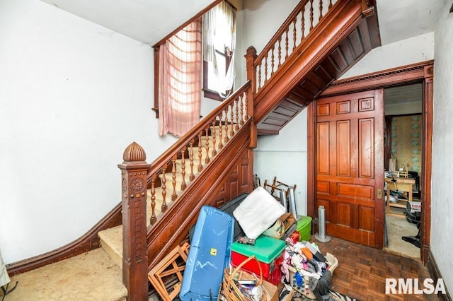 stairway featuring parquet flooring