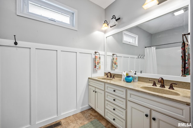 bathroom with a shower with curtain, tile patterned flooring, and vanity