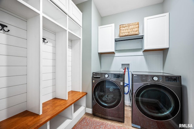 washroom with washer and clothes dryer and cabinets