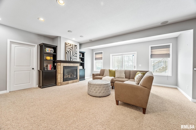 carpeted living room featuring a tile fireplace