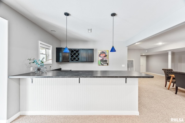 kitchen with kitchen peninsula, a kitchen bar, and decorative light fixtures