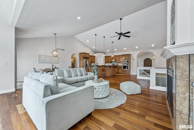 living room with hardwood / wood-style flooring, ceiling fan, and lofted ceiling