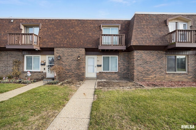 view of property featuring a front yard and a balcony