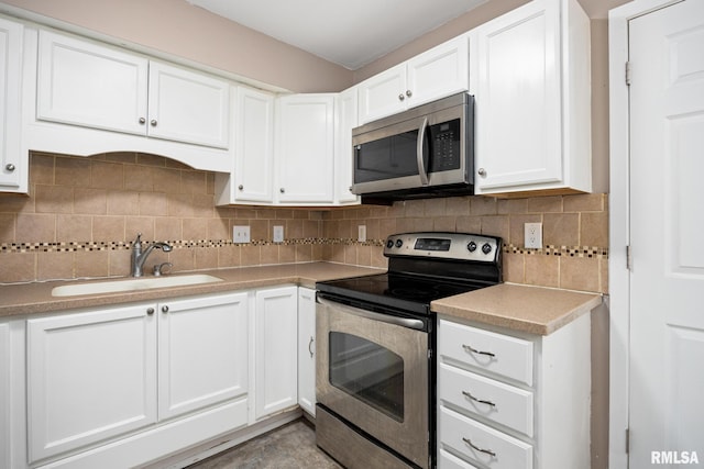 kitchen with white cabinets, backsplash, sink, and stainless steel appliances