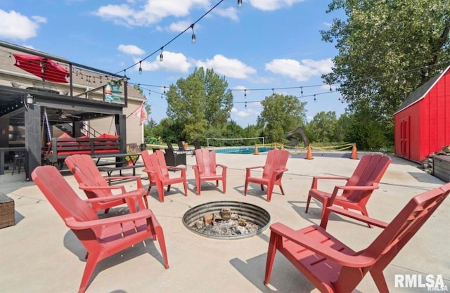 view of patio / terrace featuring a fire pit and a swimming pool