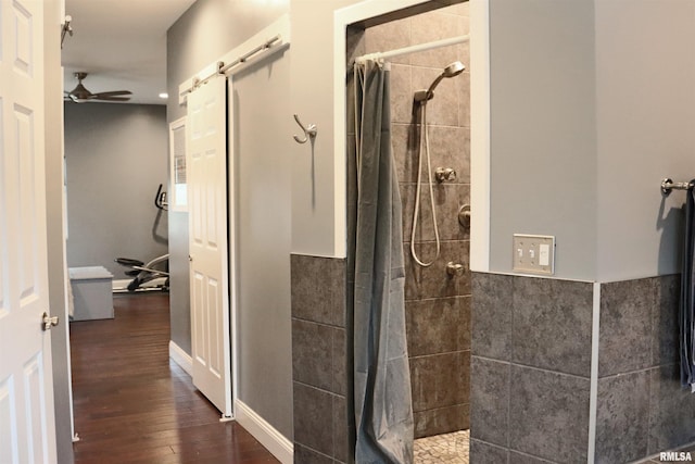 bathroom featuring hardwood / wood-style floors, ceiling fan, and curtained shower